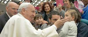 Der Papst begrüßt Ende Januar ein Kind in der Audienzhalle des Vatikans. Mit seiner Predigt über die Rolle des Vaters hat Franziskus viel Aufsehen erregt. Ihm wird vorgeworfen, Gewalt gegen Kinder zu relativieren.
