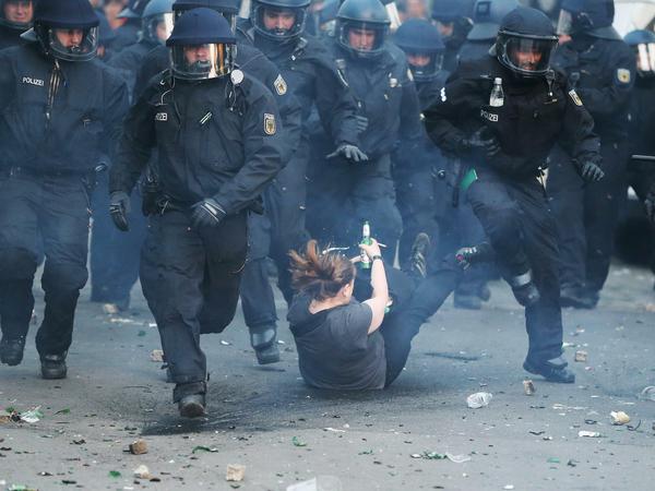 Beim Rangeln mit Polizisten geht bei der Demonstration linker Gruppen zum 1. Mai 2016 in Kreuzberg eine Frau zu Boden.
