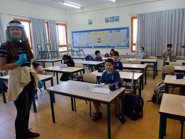 Israel, Modi'in: Eine Lehrerin steht mit einem Gesichtsschutz vor Kindern in einer Klasse. 