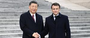 Xi Jinping und Emmanuel Macron begrüßen sich in Peking.