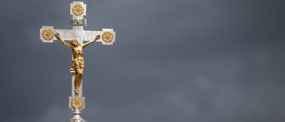 Mai 2022: Ein Kruzifix ist beim Schlussgottesdienst des 102. Deutschen Katholikentags vor dunklen Wolken zu sehen.