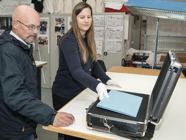 Restauratorin Iris Lasetzke legt Registrar Volker Thiel die Mappe in den Koffer.