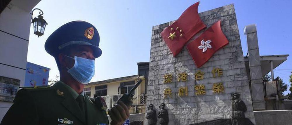 Ein chinesischer Polizist mit Schutzmaske steht in der Nähe der Grenze zu Hongkong.