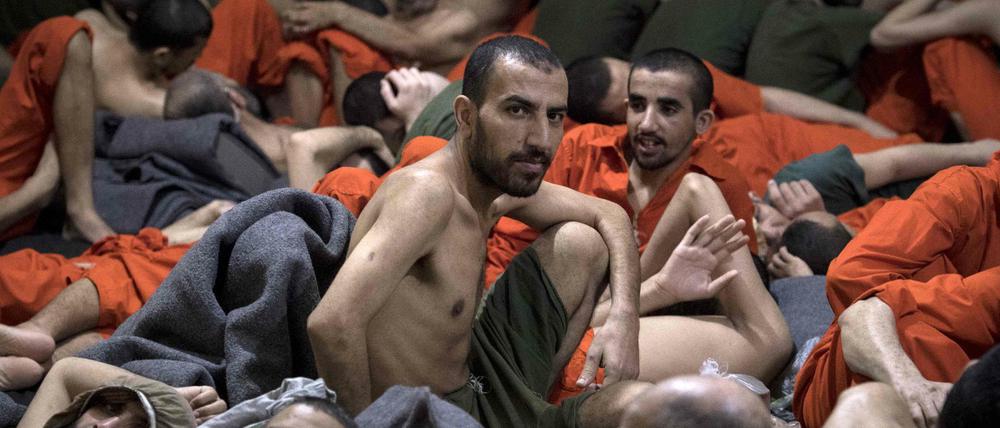 Männer, die als IS-Kämpfer gelten, sitzen in einem Gefängnis in Syrien.