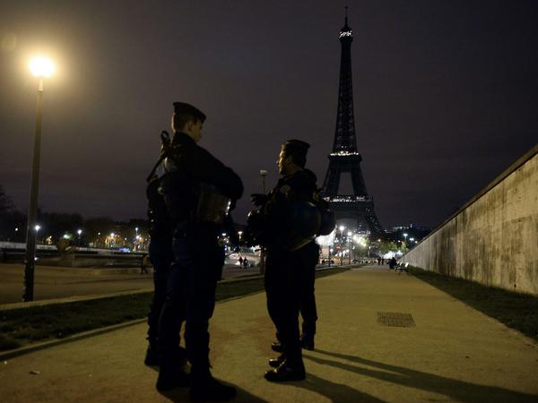 Polizisten am Samstagabend vor dem dunklen Eiffelturm.
