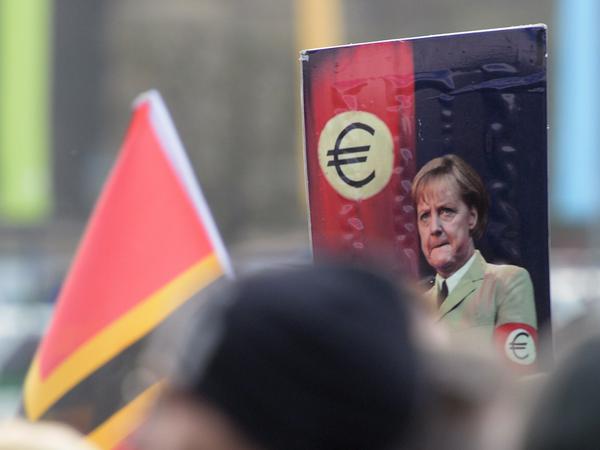Ein Plakat bei der Pegida-Demonstration am 19. Oktober zeigt Bundeskanzlerin Angela Merkel in Nazi-Pose. Der Präsident des Zentralrats der Juden in Deutschland, Josef Schuster, bezeichnet die rechtsextremen Parolen als "inakzeptabel". 