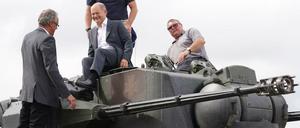 Bundeskanzler Olaf Scholz (Mitte) klettert auf einen Gepard Panzer.