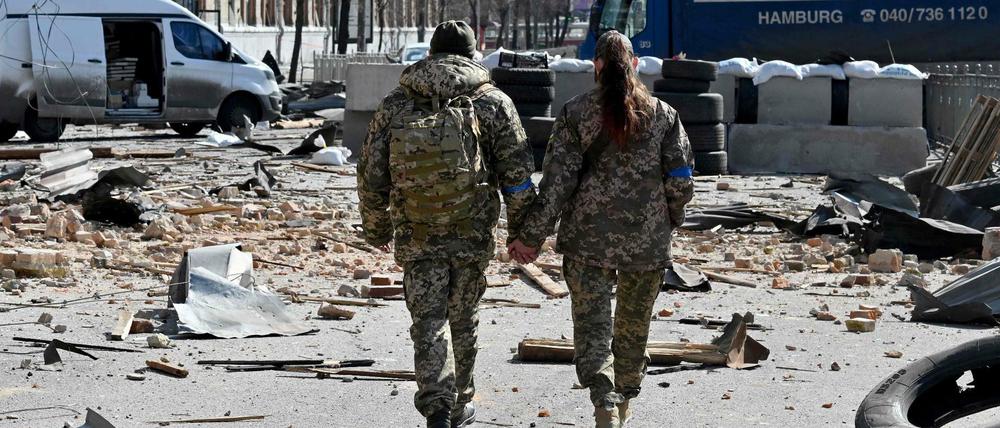 Zwei ukrainische Soldaten laufen Hand in Hand durch Kiew.