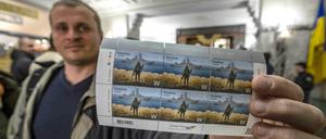 Ein Ukrainer mit der Kriegs-Briefmarke in Kiew.