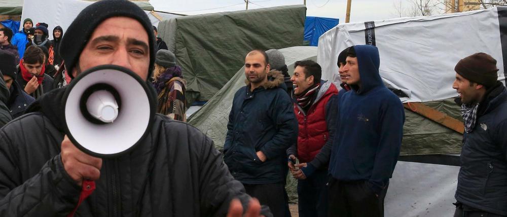 Flüchtlinge protestierten, als eine Richterin am Dienstag den "Dschungel" in Calais besuchte.