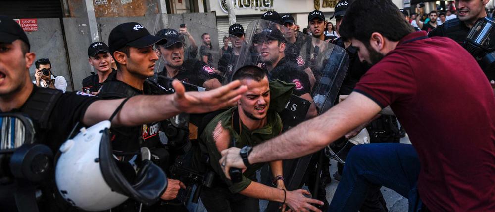 Brutales Vorgehen: Ein Polizist in Zivil (r.) tritt einen der Demonstranten. 