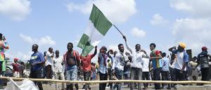 Ein Demonstrant schwenkt bei Protesten die nigerianische Flagge.