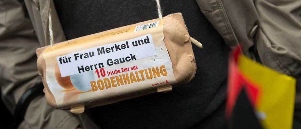 Ein Pegida-Anhänger in Dresden mit einem Eier-Karton - "für Frau Merkel und Herrn Gauck".