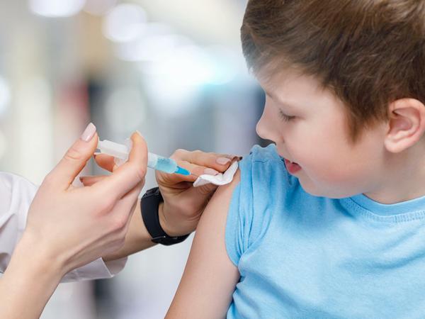 Ein Jugendlicher bekommt einen Impfstoff von einem Kinderarzt gespritzt.