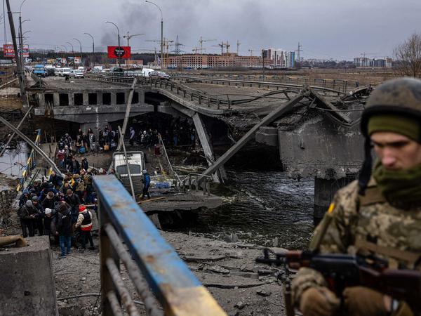 Ein ukrainischer Soldat vor einer zerstörten Brücke in der Stadt Irpin. 