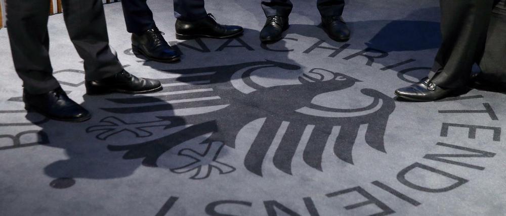 Männer stehen auf einem Teppich mit dem Logo des Geheimdienstes während der Eröffnung des Besucherzentrums des Bundesnachrichtendienstes (BND).