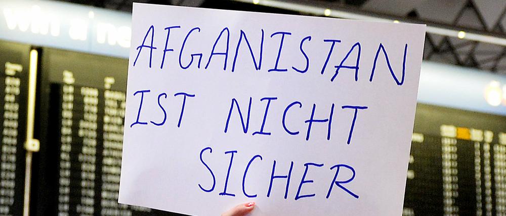 Eine Demonstrantin protestiert am Flughafen in Frankfurt am Main gegen Abschiebungen nach Afghanistan. 
