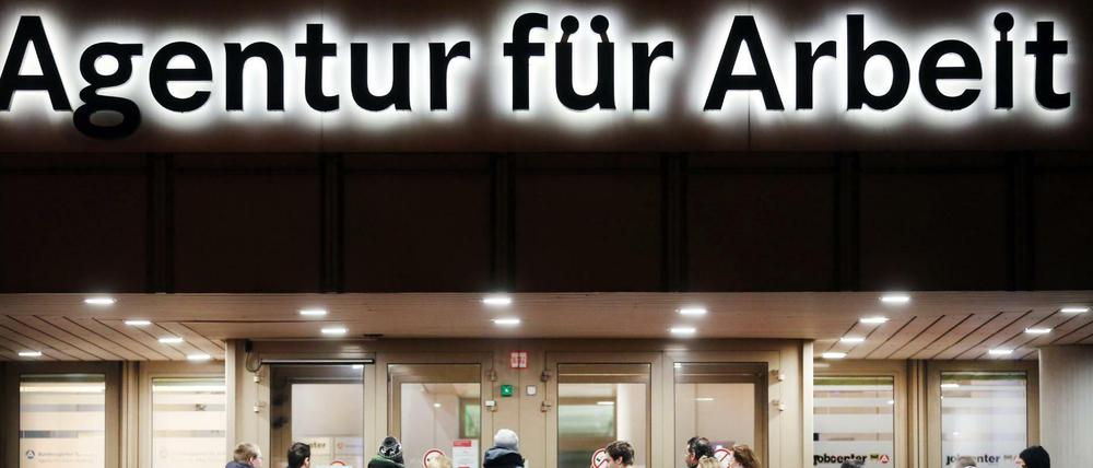 Arbeitssuchende stehen vor der Bundesagentur für Arbeit in Duisburg.