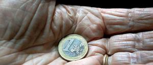 In der Hand eines alten Menschen liegt eine Euro-Münze
