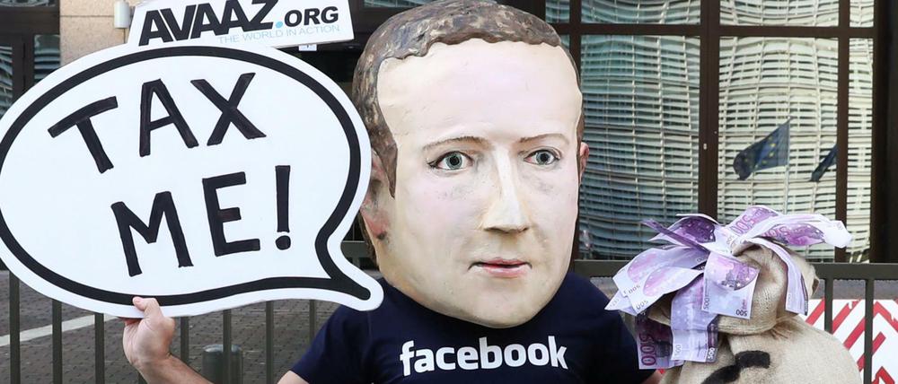 Ein Aktivist mit einer Maske von Facebook-Chef Mark Zuckerberg protestiert in Brüssel für eine Digitalsteuer.
