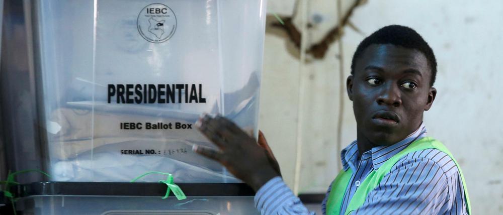 Ein Mitarbeiter der Wahlkommission stapelt in Nairobi Kisten mit Stimmzetteln.