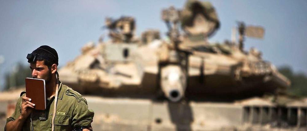 Ein israelischer Soldat betet vor einem Panzer im Gazastreifen, aufgenommen am Donnerstag den 24. Juli. 