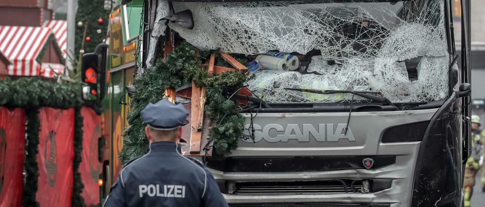 Ein Polizist steht vor dem Tatfahrzeug am Weihnachtsmarkt am Breitscheidplatz.