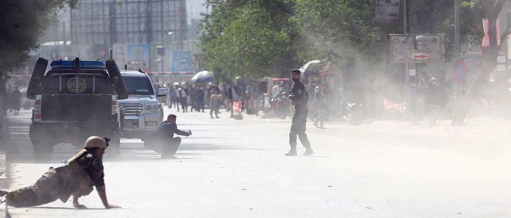 Sicherheitskräfte und Zivilisten gehen während einer der Explosionen in Deckung.
