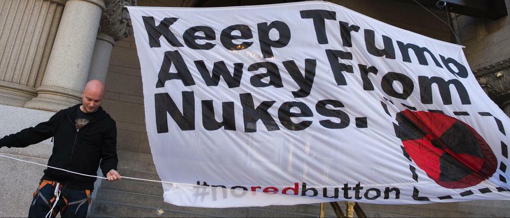 Ein Aktivist vor dem Trump International Hotel in Washington mit einem Banner, das vor Donald Trumps Atomplänen warnt. 