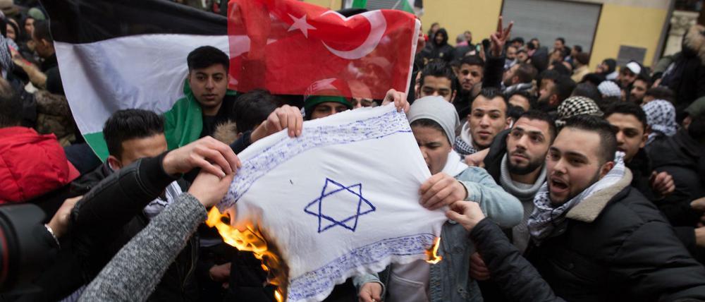 Antisemitismus auf der Straße: Teilnehmer einer Demonstration verbrennen eine selbstgemalte Fahne mit einem Davidstern in Neukölln.
