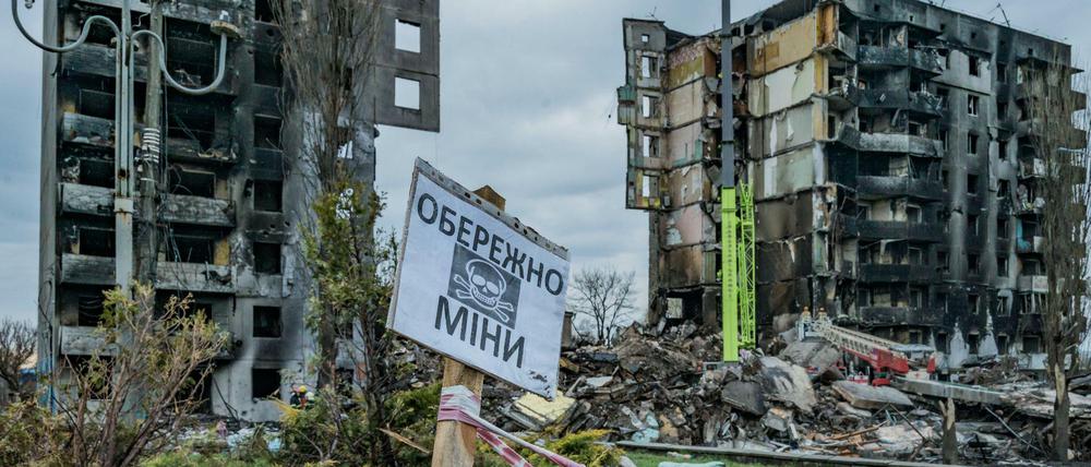 Ein Schild warnt in einem zerbombten Wohngebiet nahe Kiew vor Minen.