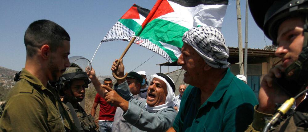 Unversöhnlich. Palästinensische Demonstranten in Nablus protestieren vor israelischen Soldaten gegen den Bau einer neuen Straße für jüdische Siedler in der besetzten West-Bank (25. August 2021).