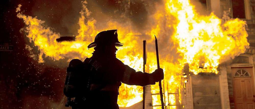 Ein Feuerwehrmann vor einem in Brand gesteckten Gebäude in Baltimore.