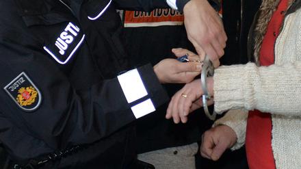 Einem Mitglied des Miri-Clans werden im Prozess um unerlaubten Betäubungsmittelhandel im Saal des Landgerichts in Bremen von einem Justizbeamten die Handschellen abgenommen.