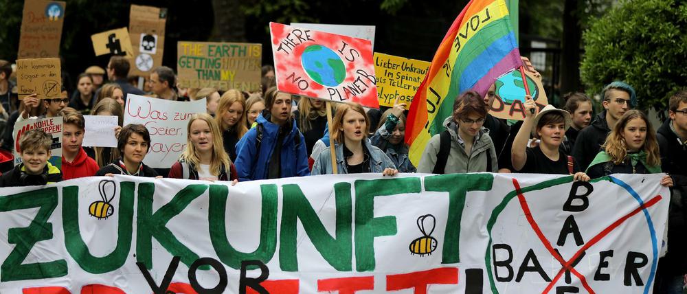  Klima-Aktivisten der "Fridays for Future"-Bewegung halten auf dem Weg zur Hauptversammlung von Bayer ein Transparent mit der Aufschrift "Zukunft vor Profit". 