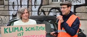 Ein Angeklagter (r) im Prozess gegen zwei Klimaschützer nach Straßenblockaden in Stuttgart spricht bei einer Kundgebung vor dem Gerichtsgebäude (Archivbild).