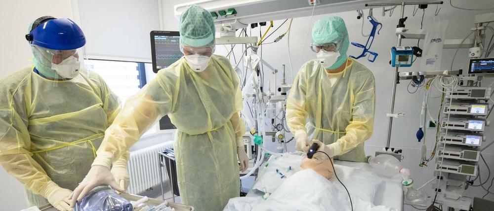 Ärzte und Pfleger demonstrieren das Intubieren bei einem Covid-19 Patienten an einer Patienten-Simulationspuppe.
