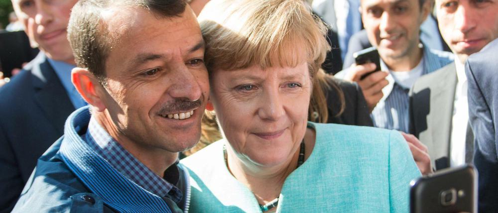 Ungewöhnlich nahbar. Bundeskanzlerin Angela Merkel (CDU) lässt sich am 10.09.2015 nach dem Besuch einer Erstaufnahmeeinrichtung für Asylbewerber in Berlin für ein Selfie zusammen mit einem Flüchtling fotografieren. 