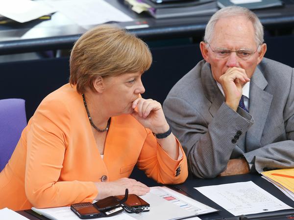 Bundeskanzlerin Angela Merkel (CDU) sitzt mit Bundesfinanzminister Wolfgang Schäuble (CDU) am 01.07.2015 im Bundestag in Berlin. In der Sitzung befasst sich der Bundestag mit der Griechenland-Schuldenkrise. 