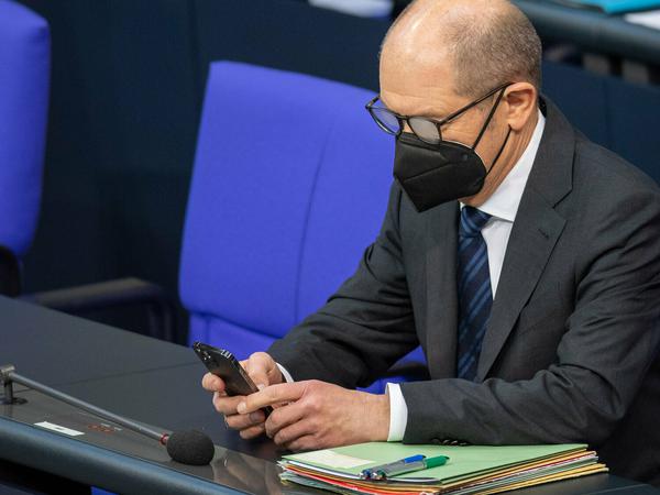 Nachdem die Opposition die Koalition überstimmt hatte, wurde Vizekanzler Olaf Scholz am Mittwoch in den Bundestag beordert, wo er sein Mobiltelefon nutzte.
