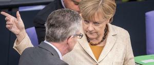 Bundesinnenminister Thomas de Maiziere (CDU) spricht mit Bundeskanzlerin Angela Merkel (CDU) am 01.10.2015 im Bundestag in Berlin. 