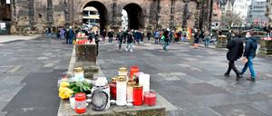 Menschen haben Kerzen und Blumen für die Opfer der Amokfahrt vor der Porta Nigra abgelegt.