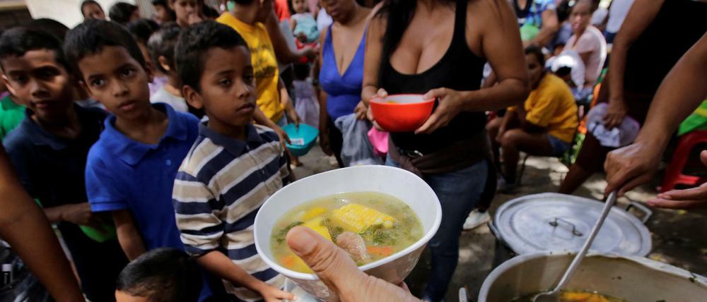 Kinder aus armen Familien stehen in den Suppenküchen von Caracas Schlange. 