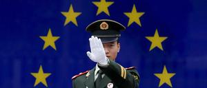 Ein chinesischer Polizist vor der Flagge der Europäischen Union.