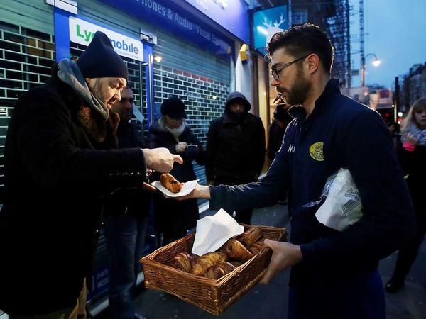Très francais: Während diese Menschen in London darauf warten, dass die Verkaufsstelle für "Charlie Hebdo" öffnet, bekommen sie Croissants verkauft.