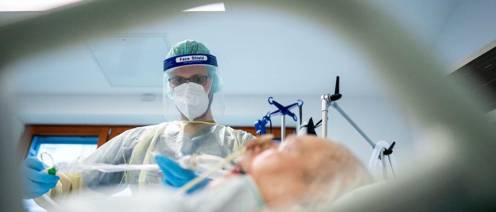 Ein Intensivpfleger versorgt im Berliner Krankenhauses Bethel einen Corona-Patienten.