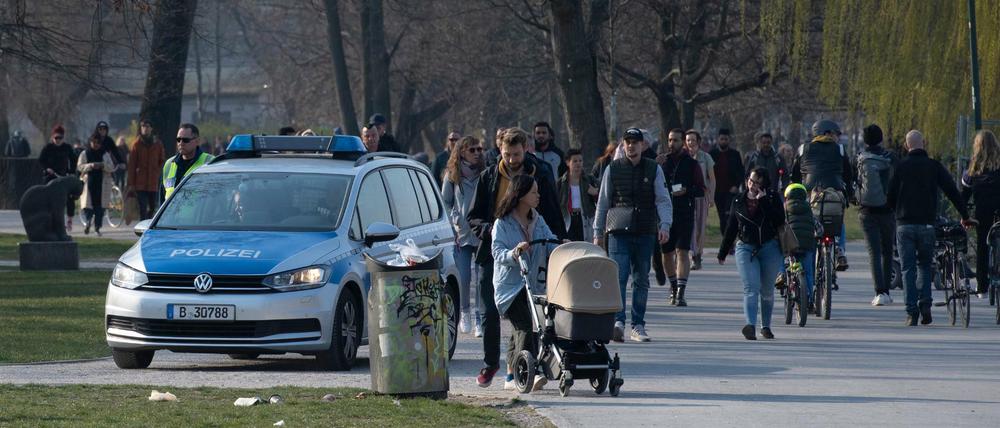 Eine Polizeistreife fährt Ende März durch den Treptower Park in Berlin und fordert die Menschen auf, die Wiese zu verlassen. 