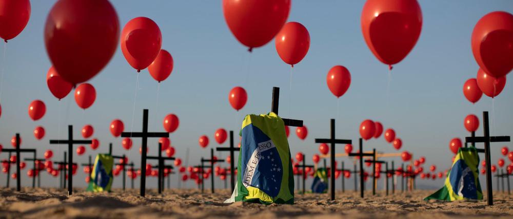  Die Nichtregierungsorganisation ´Rio de Paz» platzierte zum Gedenken der Opfer der Covid-19-Pandemie 1000 rote Luftballons und 100 Kreuze am Strand der Copacabana. 
