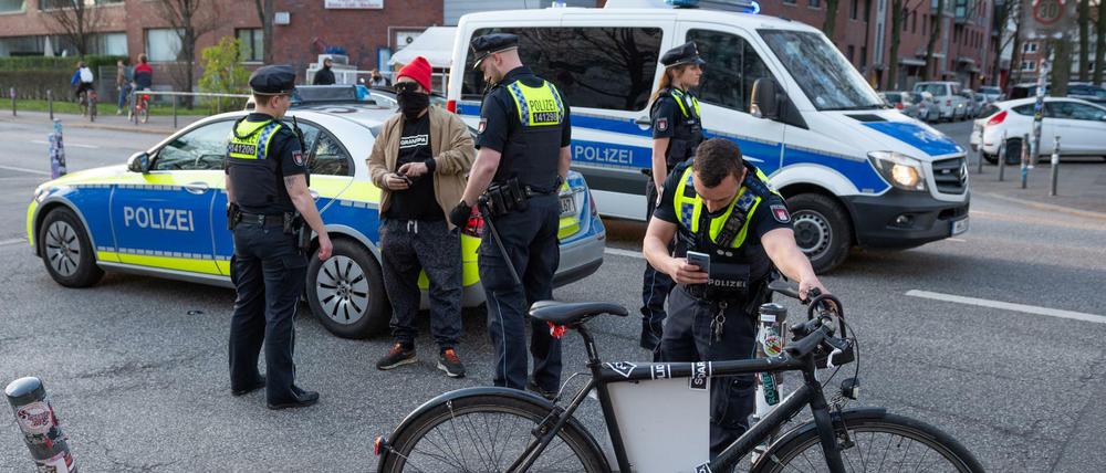 Polizisten in Hamburg kontrollieren einen Demonstranten.