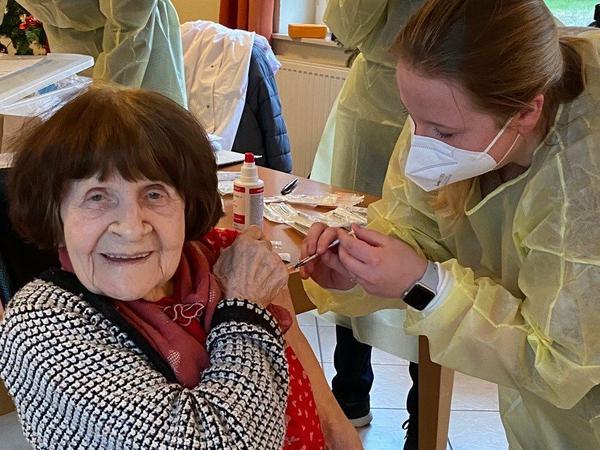 In einem Seniorenheim in Mecklenburg-Vorpommern erhält eine Bewohnerin eine Corona-Impfung